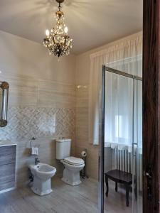 a bathroom with a toilet and a chandelier at Villa Sara in Taormina +57 photos