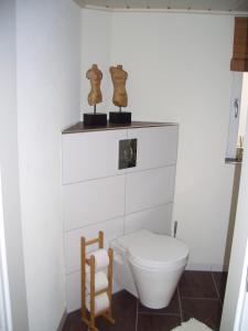 Baño blanco con aseo y silla en Schrammi's Ferienwohnung, en Schwanau