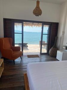 a bedroom with a bed and a view of the ocean at Wild Wood x Hansa Beach Fitness Resort in Thongsala