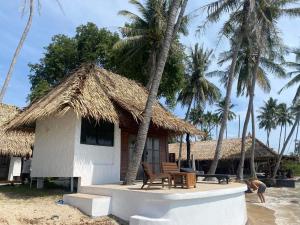 uma cabana na praia com palmeiras em Wild Wood x Hansa Beach Fitness Resort em Thongsala