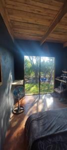 a bedroom with a bed and a large window at Hartbees Eco Bush Lodge 1 in Hartbeespoort