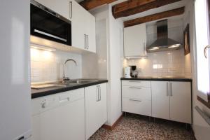 a kitchen with white cabinets and a sink at City Apartments Cannaregio in Venice