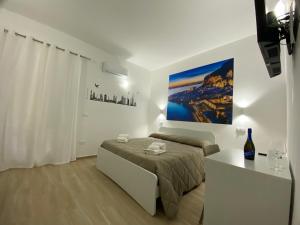 una camera bianca con letto e tavolo di IN CENTRO ROOMS Vicino Cefalù SELF-CHEK-IN a Campofelice di Roccella