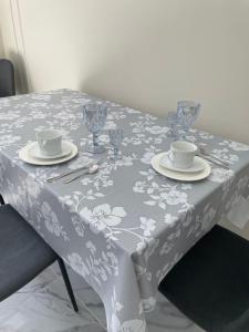 a table with a table cloth with cups and saucers at 1 комн квартира in Oral