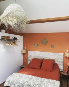 a bedroom with a bed with an orange wall at Villa Belharra in Beychac-et-Caillau