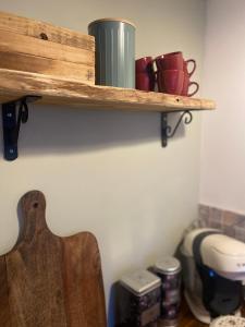 a wooden shelf on the wall with cups and a guitar at Villa Belharra in Beychac-et-Caillau