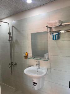 een badkamer met een wastafel en een spiegel bij Nhà Nghỉ Ngọc Ánh in Ấp Tam Tân