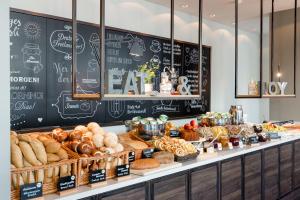 a bakery counter with bread and other baked goods at Motel One München - Deutsches Museum in Munich