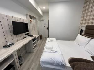 um pequeno quarto com uma cama e uma televisão de ecrã plano em Hotel Innception em Colônia