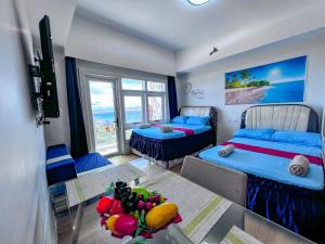 a room with two beds and a table with fruit on it at OceanFront at Arterra, fast WiFi, NFlix, kitchen - H or L in Mactan