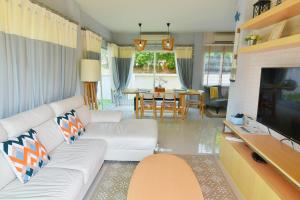 un salon avec un canapé blanc et une télévision dans l'établissement Tascany Sea Beach Chaam-Huahin, à Cha Am