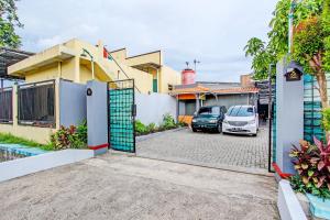 a gate to a house with a car parked in a parking lot at Hotel O Amole Paviliun Syariah in Cilacap