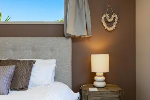 a bedroom with a bed and a window at Ocean View Beachfront Apartment in Blenheim