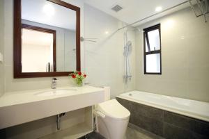 een badkamer met een wastafel, een toilet en een bad bij Sumitomo9 Apartments & Hotel - alley 58 Dao Tan in Hanoi