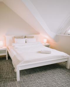 a white bed in a room with two tables at Karczma Viking in Stara Kiszewa