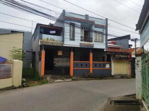 uma rua vazia com um edifício com colunas laranja em SPOT ON 92338 Karin Kost em Banjarbaru