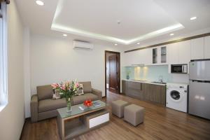 een woonkamer met een bank en een keuken bij Sumitomo9 Apartments & Hotel - alley 58 Dao Tan in Hanoi