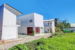 una casa bianca con porte rosse in un cortile di Super OYO Collection O 92363 Kp Inn a Yogyakarta