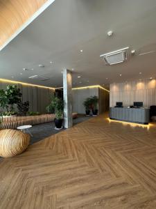 Habitación grande con suelo de madera y vestíbulo. en Roxy Hotel Aiman en Kuching