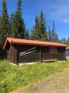 une cabane en rondins avec un toit rouge dans l'établissement Fjällgården Grövelsjön Gamla Scoutgården, à Grövelsjön