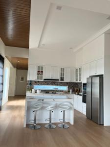 a kitchen with white cabinets and stainless steel appliances at TANJUNG GROVE VILLAS 