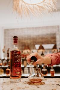 a person is holding a bottle of alcohol on a table at Palm Boutique Hôtel Nice in Nice