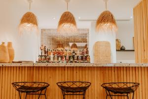 a bar with four chairs and a picture on the wall at Palm Boutique Hôtel Nice in Nice