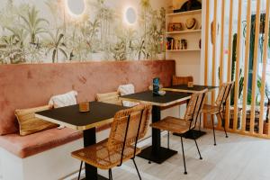- deux tables et des chaises dans un restaurant avec un canapé dans l'établissement Palm Boutique Hôtel Nice, à Nice