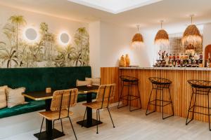 a restaurant with a bar with chairs and a green bench at Palm Boutique Hôtel Nice in Nice