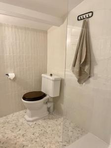 a white bathroom with a toilet with a black seat at Chalet Ameo in Valdeblore