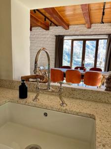 a kitchen counter with a sink and a table with chairs at Chalet Ameo in Valdeblore