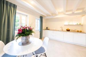 uma cozinha com uma mesa com um vaso de flores em Casa La Fattoria Fiore em Unterflockenbach