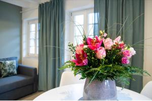 un jarrón lleno de flores rosas en una mesa en Casa La Fattoria Fiore, en Unterflockenbach