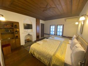 a bedroom with a large bed and a fireplace at Ebrulu Konak in Safranbolu