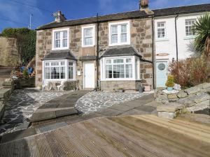 a house with a stone driveway in front of it at Beach Cottage in Kinghorn