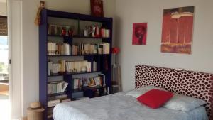 a bedroom with a book shelf filled with books at Chambre d'hôte Les Jardins Du Forcone in Ajaccio