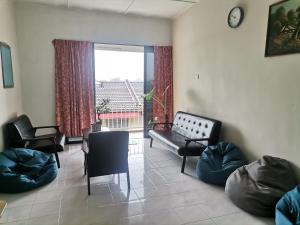 a living room with a couch and chairs and a large window at Eng Ban Hin guesthouse in Melaka