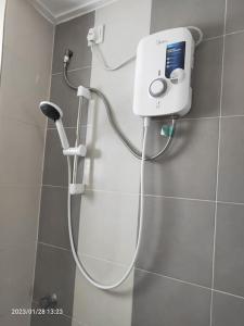 La salle de bains est pourvue d'une douche avec un pommeau de douche. dans l'établissement Casa Klebang Homestay, à Ipoh