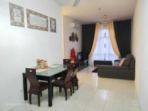 een woonkamer met een tafel en stoelen en een bank bij Casa Klebang Homestay in Ipoh