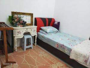 Casa Klebang Homestay في ايبوه: غرفة نوم بسرير وطاولة مع مرآة