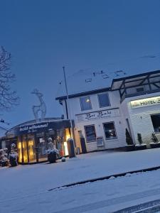 un edificio in una strada con neve per terra di Hotel & Restaurant Bei Baki a Sehnde