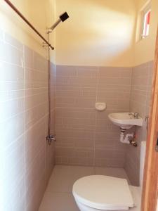 un baño con inodoro y lavabo en Baby Lee's Tourist Inn, en Corón