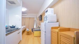 La cuisine est équipée d'un réfrigérateur blanc et d'un évier. dans l'établissement TOKYO ICHIBAN SHINJUKU, à Tokyo