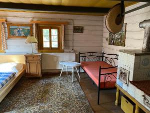 a bedroom with a bed and a table in a room at Roubenka u potoka Jizerské hory in Desná