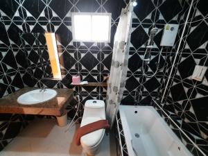 een badkamer met een toilet, een wastafel en een bad bij Fancy Carp Resort in Cha Am