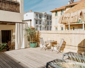 eine Terrasse mit Stühlen, einem Tisch und einem Zaun in der Unterkunft Palm Boutique Hôtel Nice in Nizza