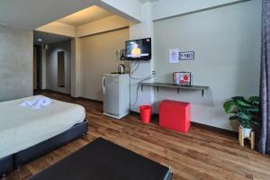 a room with a bed and a tv on a wall at Bkk39 Airport hotel in Ban Khlong Prawet