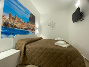 a bedroom with a bed and a tv on a wall at IN CENTRO ROOMS Vicino Cefalù SELF-CHEK-IN in Campofelice di Roccella