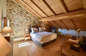 ein Schlafzimmer mit einem Bett und einer Steinmauer in der Unterkunft Maison Madamicella in Fozzano