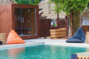 a swimming pool with orange and blue pillows next to a building at Wild Wood x Hansa Beach Fitness Resort in Thongsala